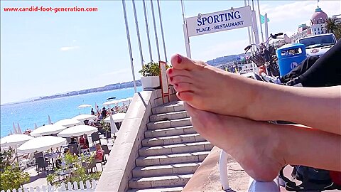 This Woman With Red Toe Nails Relaxes Her Luscious Feet On The Railing At The Beach